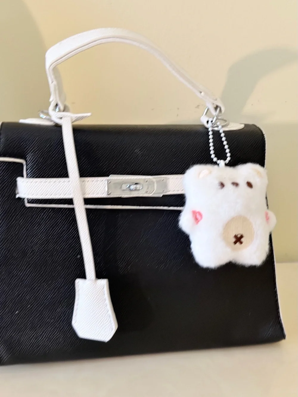 Black and White Structured Top-Handle Bag with Plush Charm